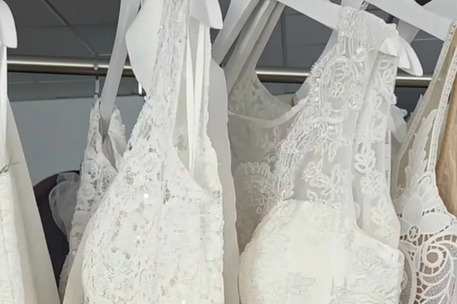 Kleiderstange mit Brautkleidern aus Spitze bei emella