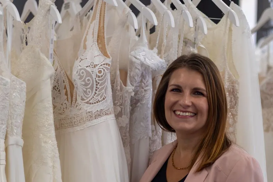 Barbara hält an der Kleiderstange ein Brautkleid