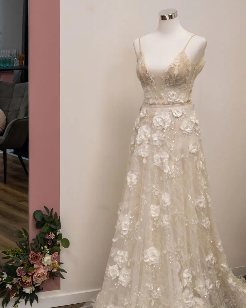 Brautkleid mit Blütenapplikationen auf einer Schneiderbüste
