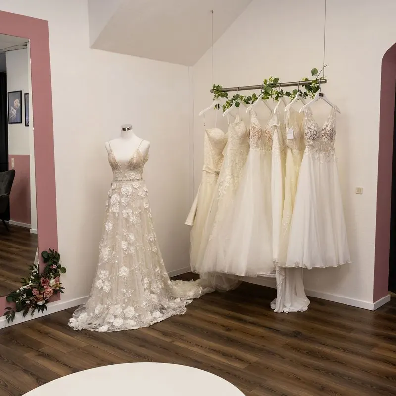 Kleiderstange mit Brautkleidern neben der Umkleide mit Rundbogen