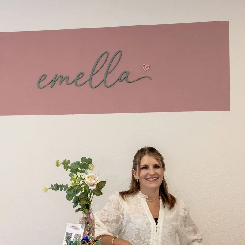 Barbara Zeidler an der weißen Theke vor der rosa emella-Wand
