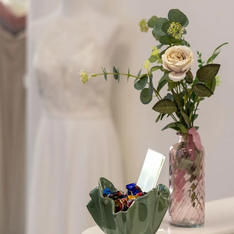 Vase mit Rose und Süßigkeitenschale auf der Theke