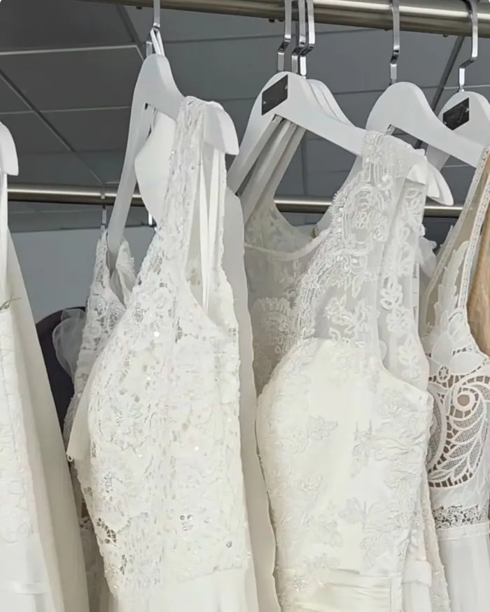 Brautkleider auf weißen Bügeln