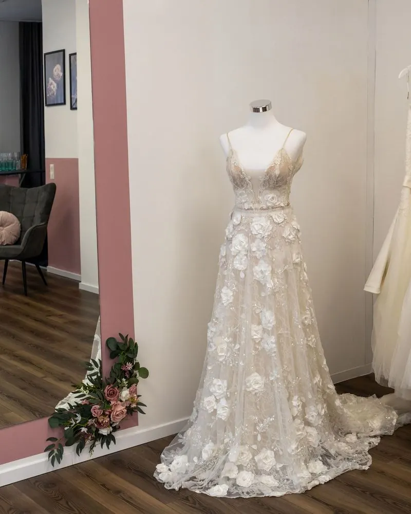 Brautkleid mit Blütenapplikationen in naturgetreuem Licht
