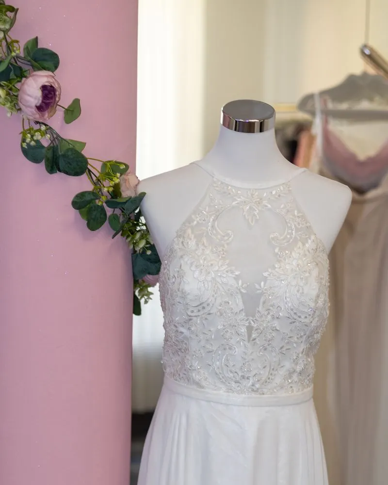 Schlichtes Standesamtkleid mit Spitzenoberteil an der rosa Säule
